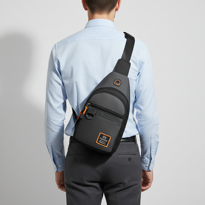 Man wearing a compact gray crossbody sling bag on the back, featuring multiple storage compartments and an adjustable shoulder strap for comfortable everyday use.